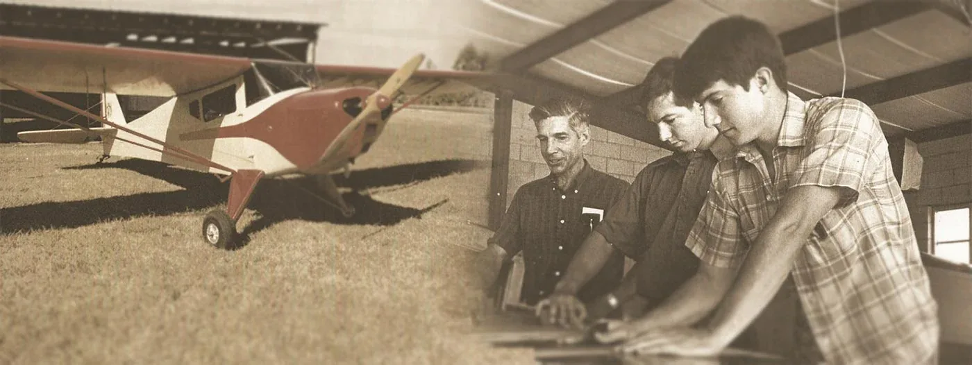 Benson Causey and his sons in the hangar at Causey Airport in Liberty, North Carolina, beside a red-and-white taildragger