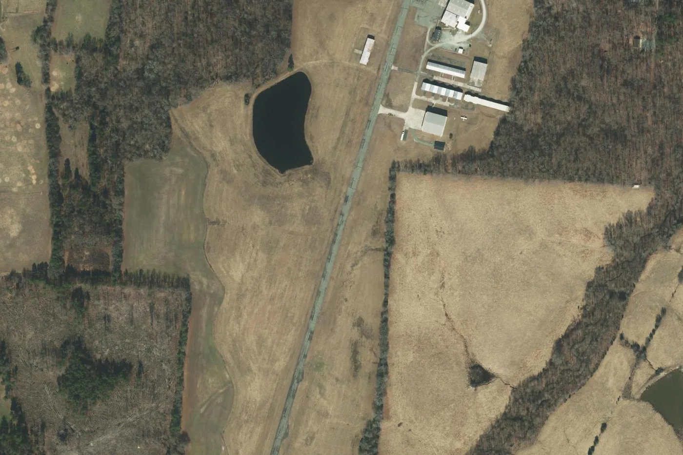 Aerial view of Causey Airport (NC74) showing the 3,800-foot runway, hangars, and open ground near Liberty, North Carolina